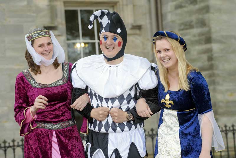 Medieval jester and maids at Winton Castle near Edinburgh