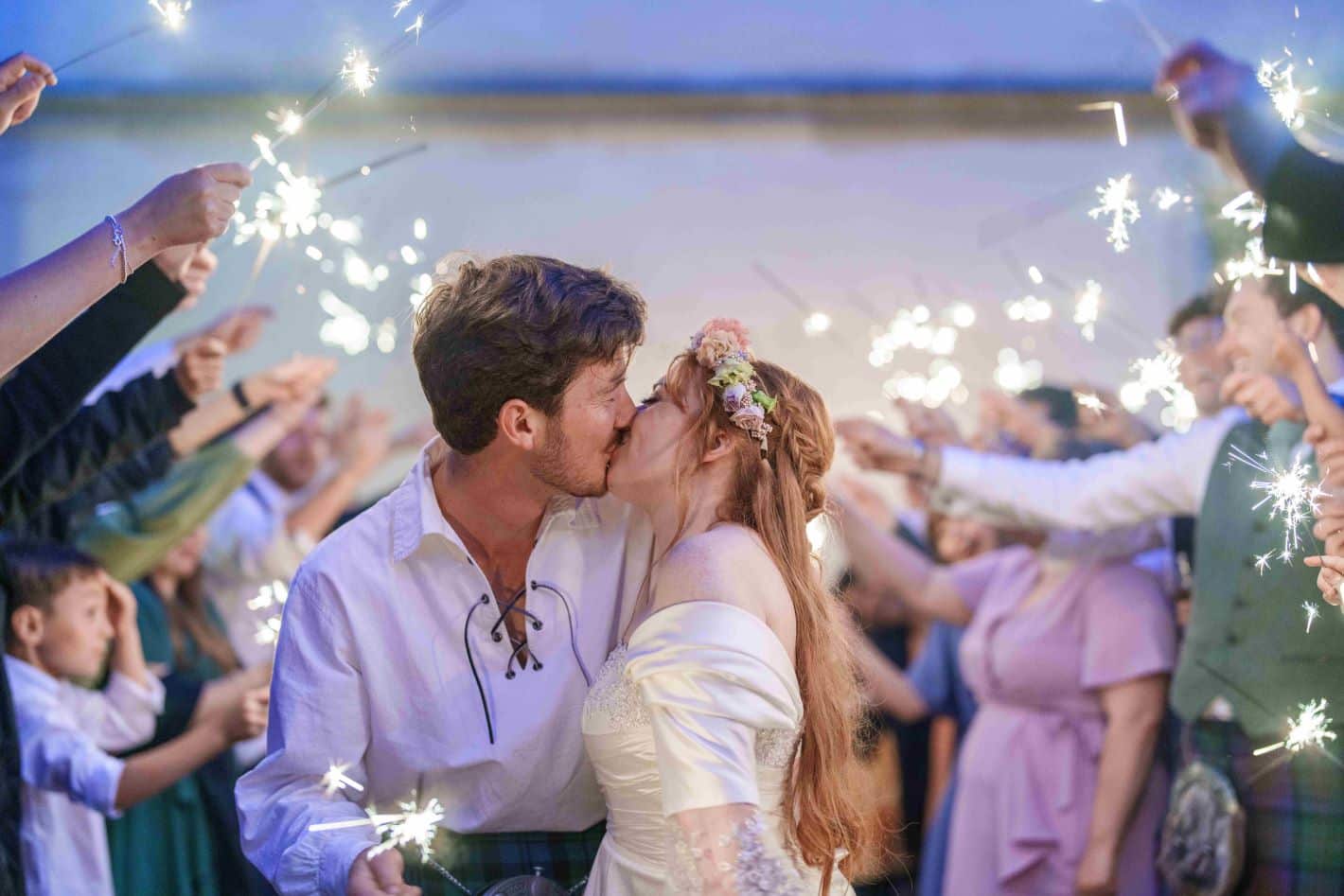 Bride and Groom kiss under sparklers